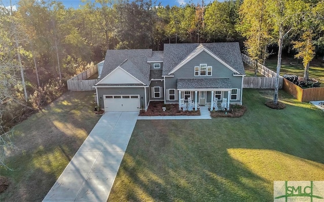 view of front of house with covered porch, a front yard, and a garage