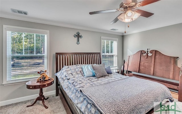 carpeted bedroom featuring ceiling fan and crown molding