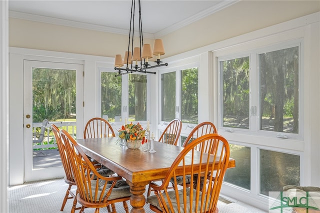 dining space featuring plenty of natural light, ornamental molding, and a notable chandelier