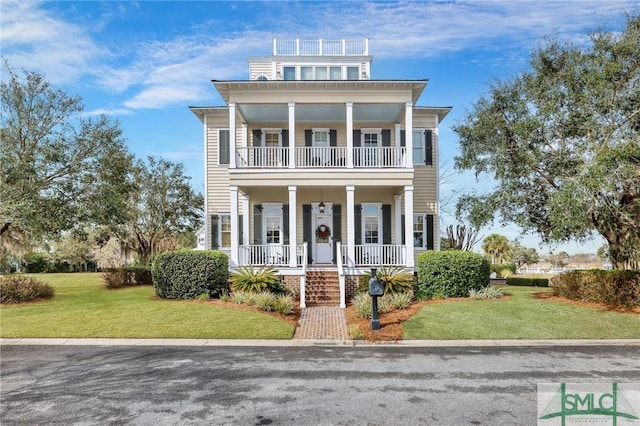 view of front of house with a front yard and a balcony