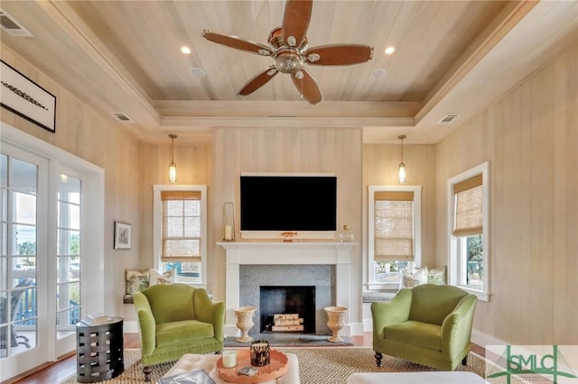 living room featuring ceiling fan, wood-type flooring, and a tray ceiling