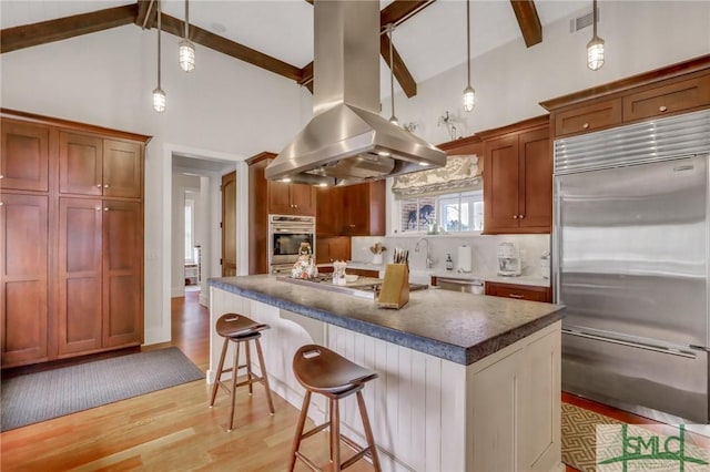 kitchen featuring island range hood, beamed ceiling, a kitchen island, and stainless steel appliances