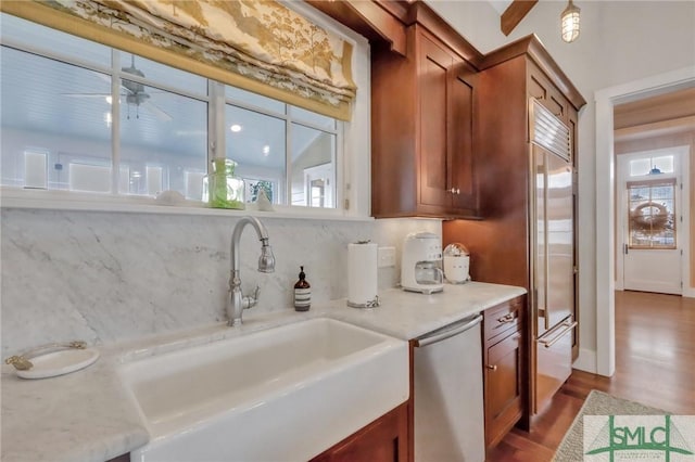 kitchen featuring a wealth of natural light, sink, stainless steel dishwasher, and hardwood / wood-style flooring