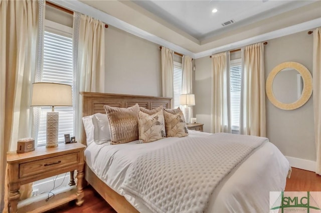 bedroom with wood-type flooring and multiple windows