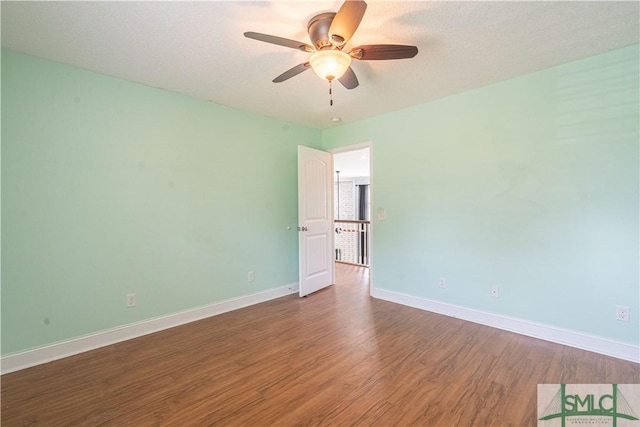 unfurnished room featuring ceiling fan, dark hardwood / wood-style flooring, and a textured ceiling