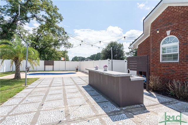 view of patio / terrace featuring a fenced in pool and exterior bar