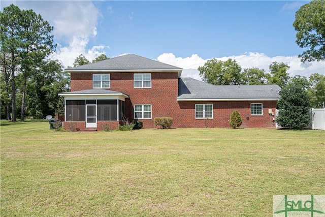 rear view of property with a lawn and a sunroom