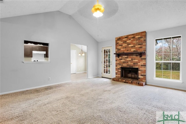 unfurnished living room with a fireplace, a textured ceiling, carpet floors, and ceiling fan with notable chandelier