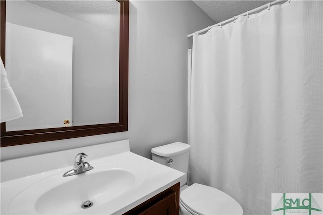 bathroom featuring vanity, a textured ceiling, and toilet