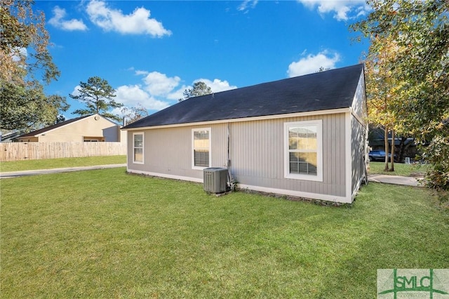 back of house with central AC and a yard