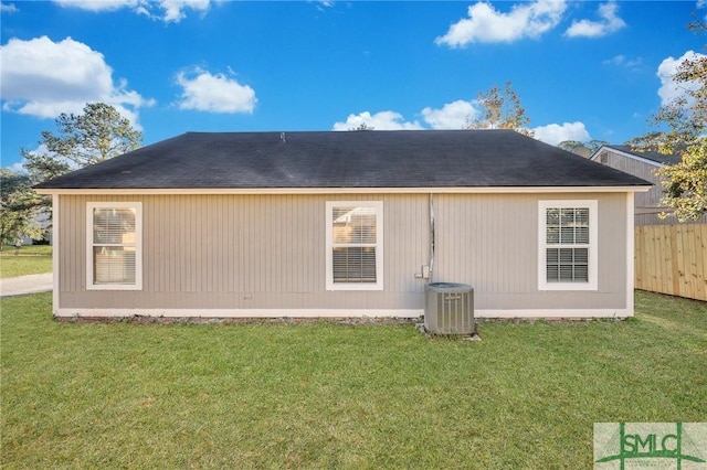 rear view of property with a lawn and central AC unit