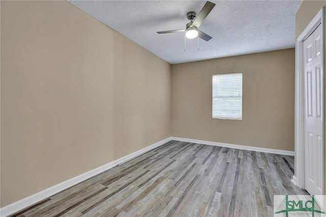 unfurnished room with ceiling fan, a textured ceiling, and light hardwood / wood-style flooring