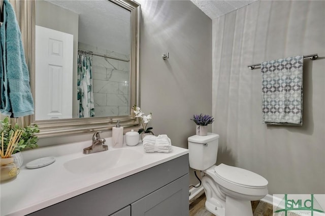 bathroom featuring hardwood / wood-style floors, vanity, toilet, a textured ceiling, and walk in shower