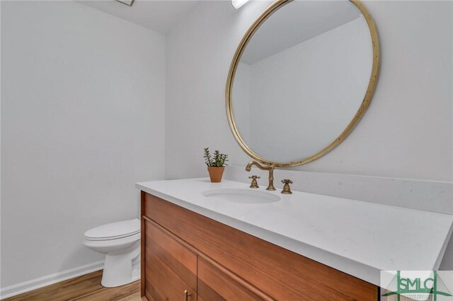 bathroom featuring hardwood / wood-style floors, vanity, and toilet