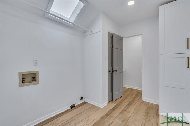 clothes washing area with electric dryer hookup, hookup for a washing machine, light hardwood / wood-style flooring, and a skylight