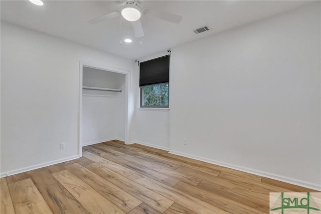 unfurnished bedroom featuring ceiling fan, light wood-type flooring, and a closet