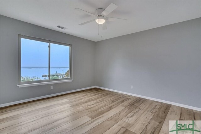 empty room with ceiling fan and light hardwood / wood-style flooring