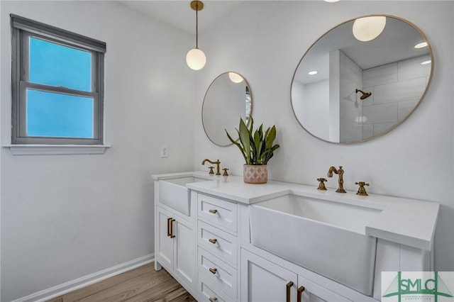 bathroom with hardwood / wood-style floors, vanity, and walk in shower