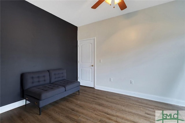 living area featuring dark hardwood / wood-style flooring and ceiling fan