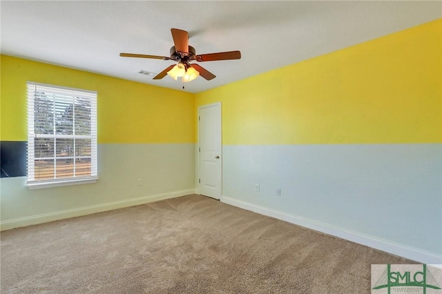 carpeted spare room featuring ceiling fan