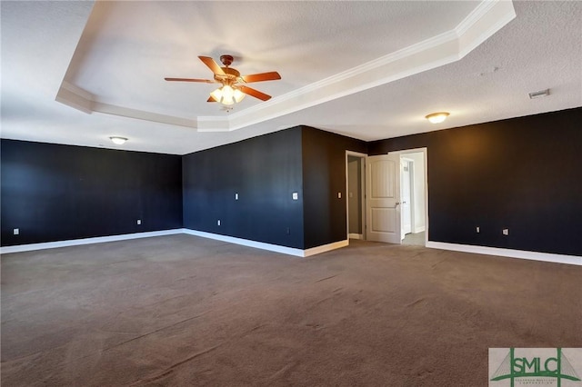 carpeted spare room featuring ceiling fan, crown molding, a textured ceiling, and a tray ceiling