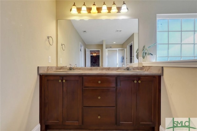 bathroom featuring a shower with door and vanity