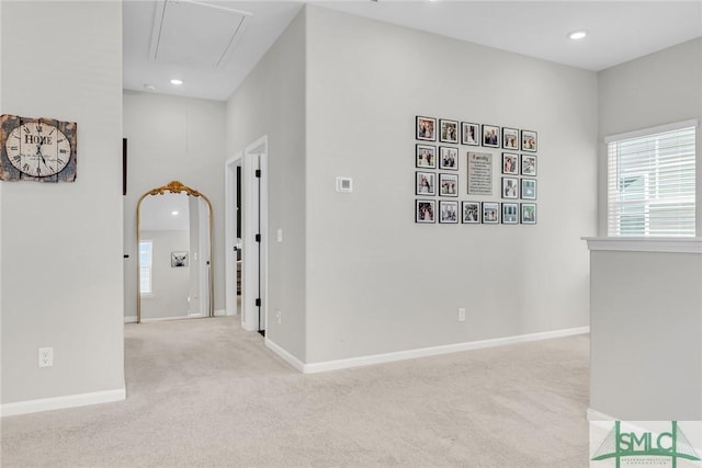 hall featuring light colored carpet