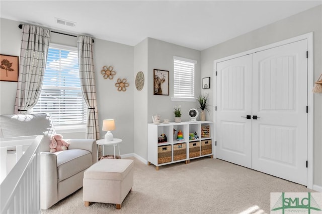 living area featuring light colored carpet and a healthy amount of sunlight