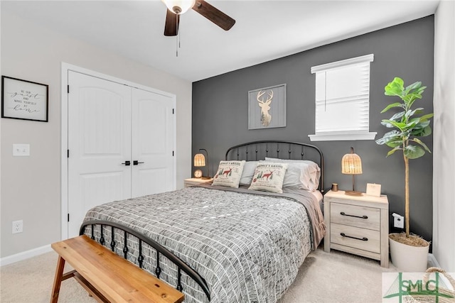 carpeted bedroom with ceiling fan and a closet