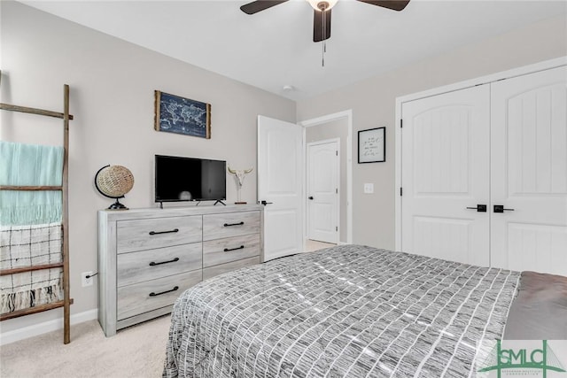 bedroom with ceiling fan, light carpet, and a closet