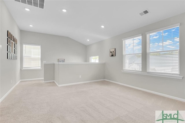 carpeted empty room with vaulted ceiling