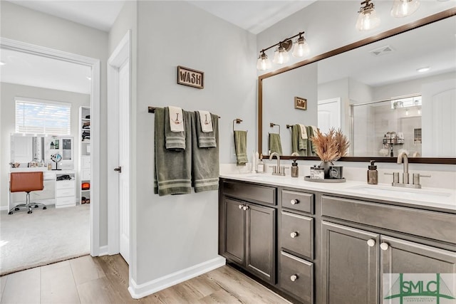 bathroom featuring wood-type flooring, vanity, and walk in shower