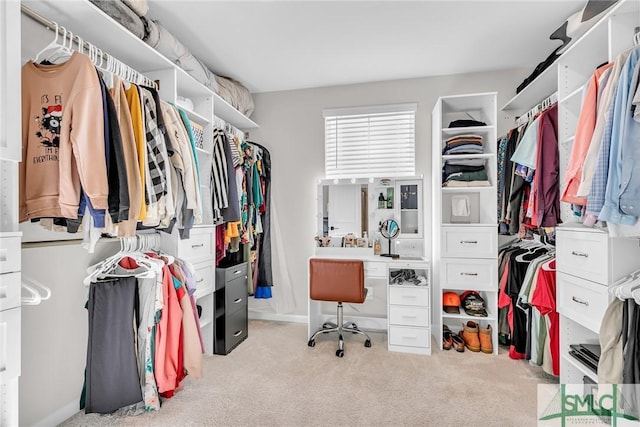 walk in closet with light carpet