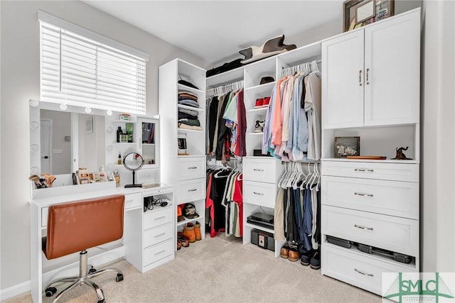 walk in closet with light colored carpet