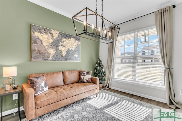 living room with a chandelier, wood-type flooring, and ornamental molding