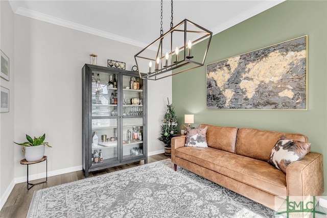 living room featuring a chandelier, dark wood-type flooring, and ornamental molding