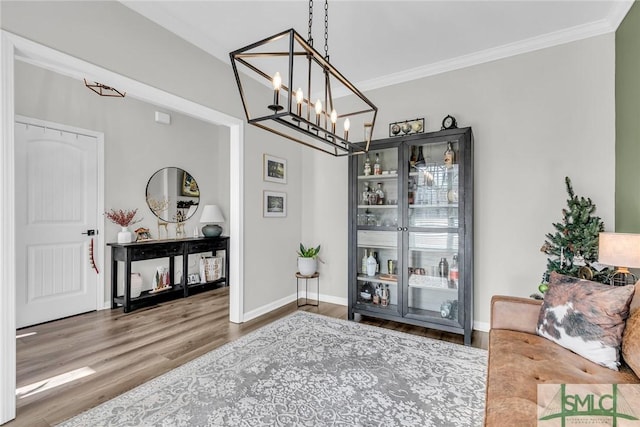 interior space featuring wood-type flooring, an inviting chandelier, and ornamental molding