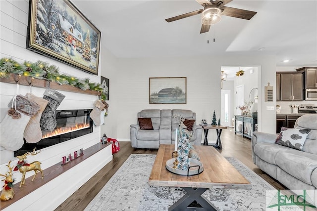 living room featuring ceiling fan and dark hardwood / wood-style flooring