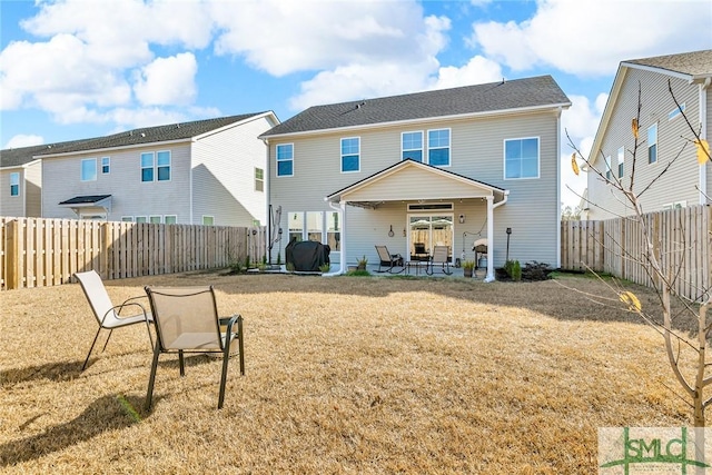 rear view of property featuring a lawn and a patio area