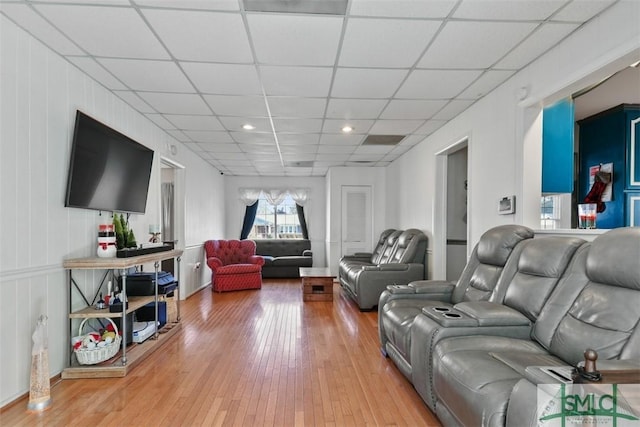 living room featuring hardwood / wood-style flooring and a drop ceiling