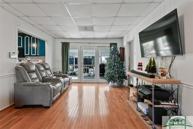 living room with light hardwood / wood-style floors and a drop ceiling