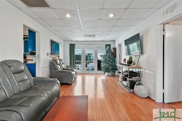 living room featuring french doors, hardwood / wood-style flooring, and a drop ceiling