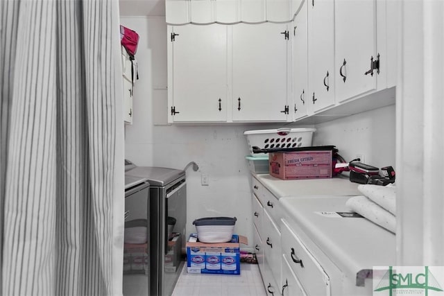 washroom featuring cabinets and separate washer and dryer