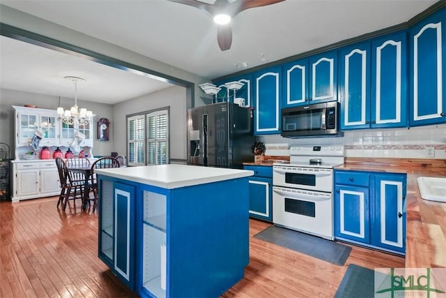 kitchen featuring white range with electric stovetop, black fridge with ice dispenser, blue cabinets, and decorative light fixtures