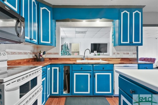 kitchen with light wood-type flooring, white appliances, and blue cabinets