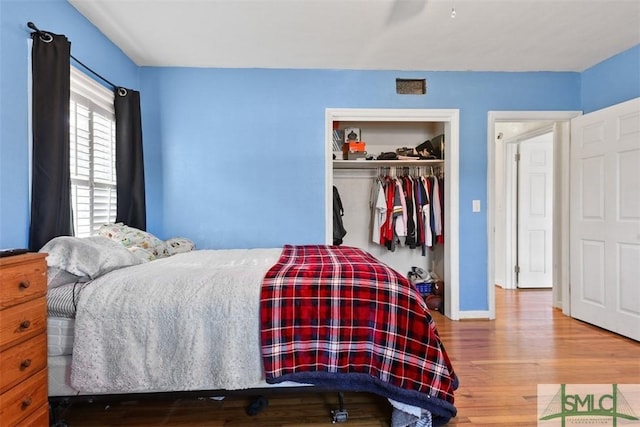 bedroom with wood-type flooring and a closet