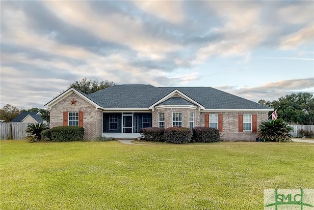 ranch-style home featuring a sunroom and a front yard