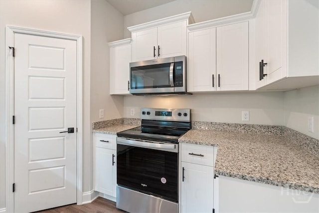 287 Timberlake Dr, Guyton, GA 31312 - kitchen featuring stainless steel appliances, white cabinetry, dark wood-style floors, and light stone counters