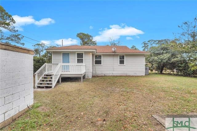 back of property featuring a deck and a yard