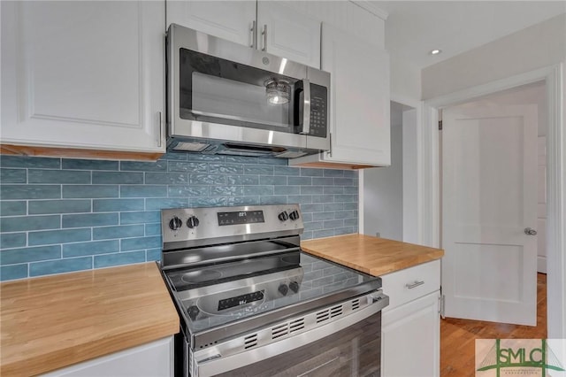 kitchen featuring appliances with stainless steel finishes, light wood-type flooring, tasteful backsplash, and white cabinetry